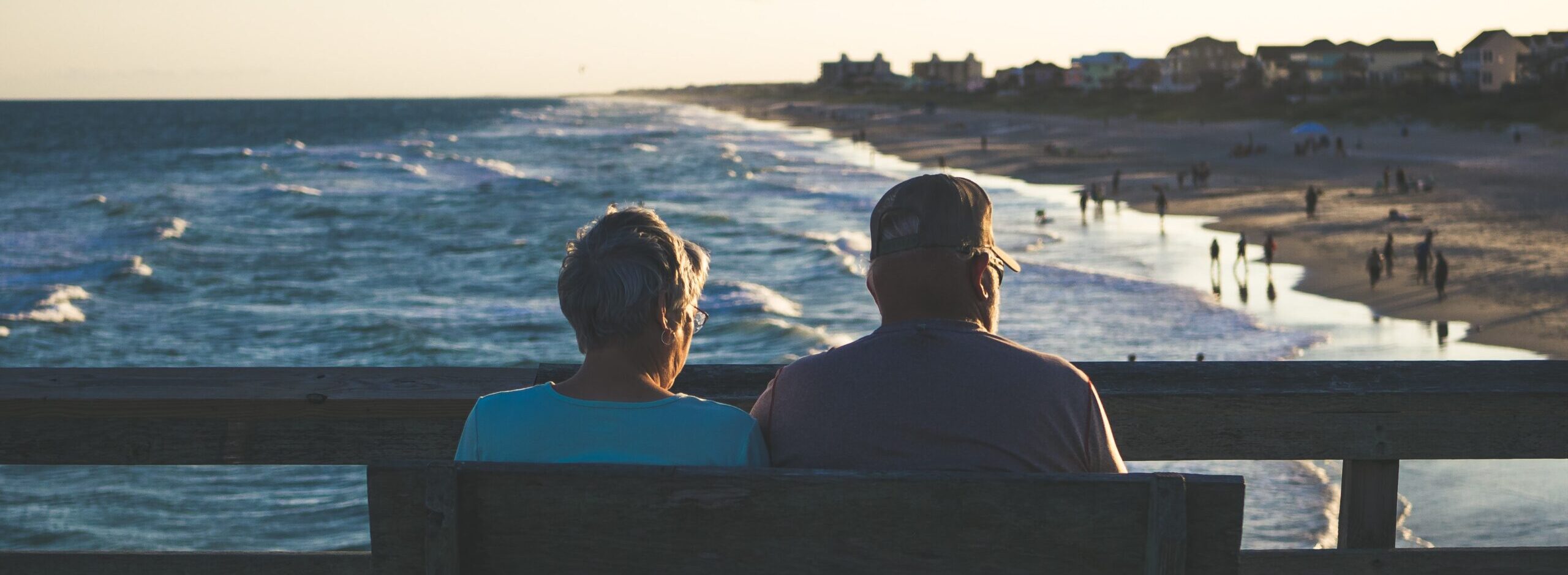 Elderly couple sitting on a bench on a pier